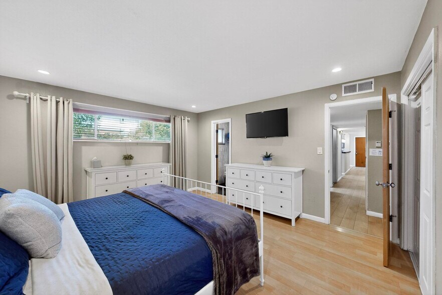 primary bedroom with king bed, attached bathroom, double closet, smartTV - 4715 Marquette Ave NE