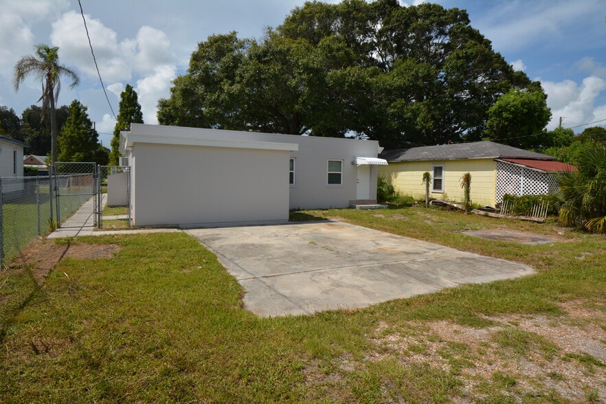 Back of unit with separate entrance to one of the bedrooms and parking. Main entry is on path to left. - 5009 TANGERINE AVE S