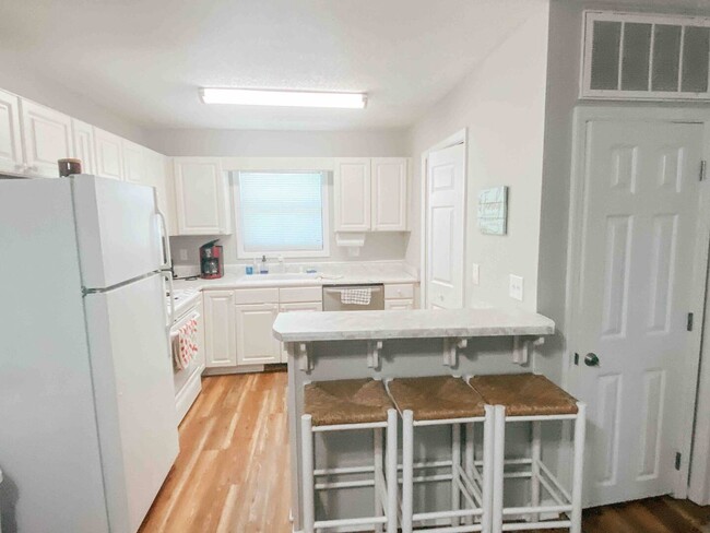 The kitchen has a breakfast bar with 3 bar stools. - 505 Carolina Beach Ave N