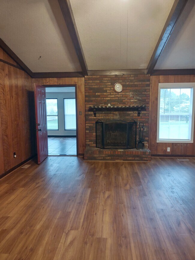 Enter home into a large Living Room, vaulted ceilings w/exposed beams & Wood burning Fireplace. - 120 Arrow Lands Trl