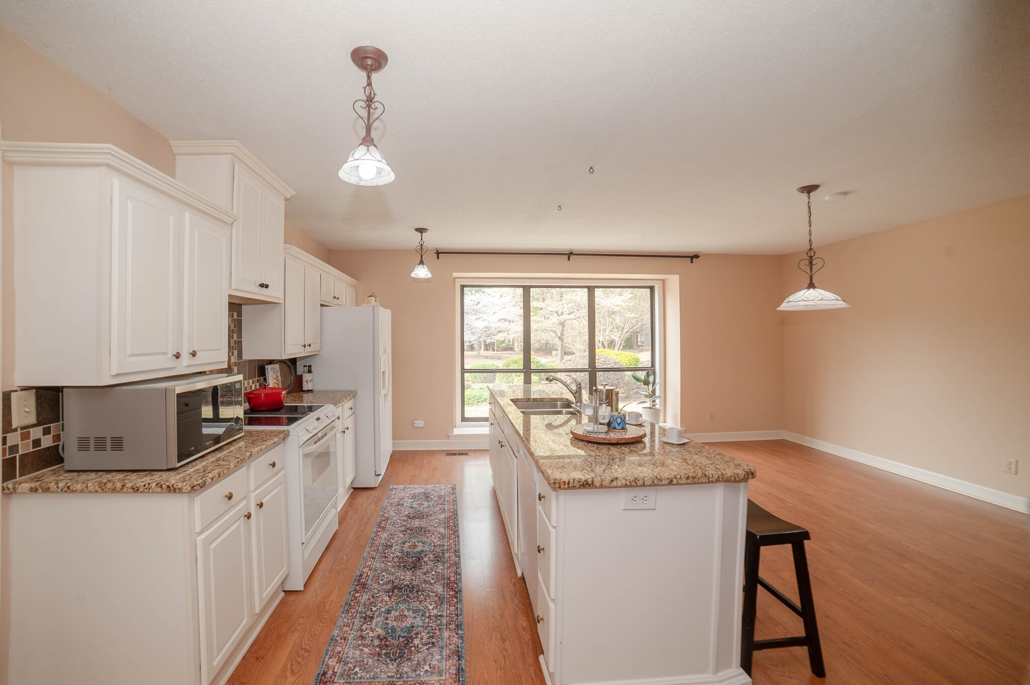 Bright, updated kitchen with granite counters and bar seating. - 6812 Uppingham Rd