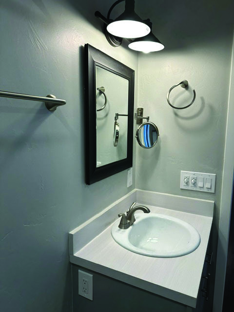 Bathroom sink with magnifying mirror. - 7079 Engineers Rd