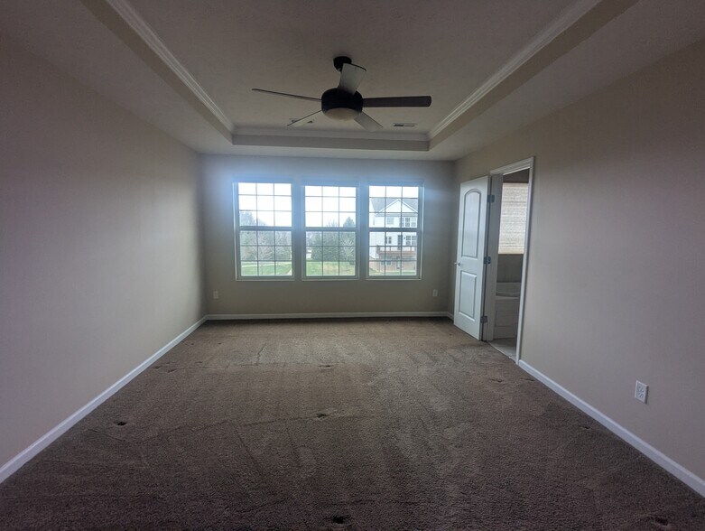 Primary suite with large windows and a spacious bathroom and closet - 6465 Park Pointe Ct