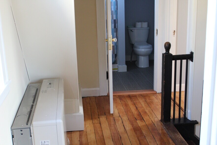 Upstairs hallway, looking toward the bathroom &amp; bedroom #2. New monitor heater. - 1011 Main St