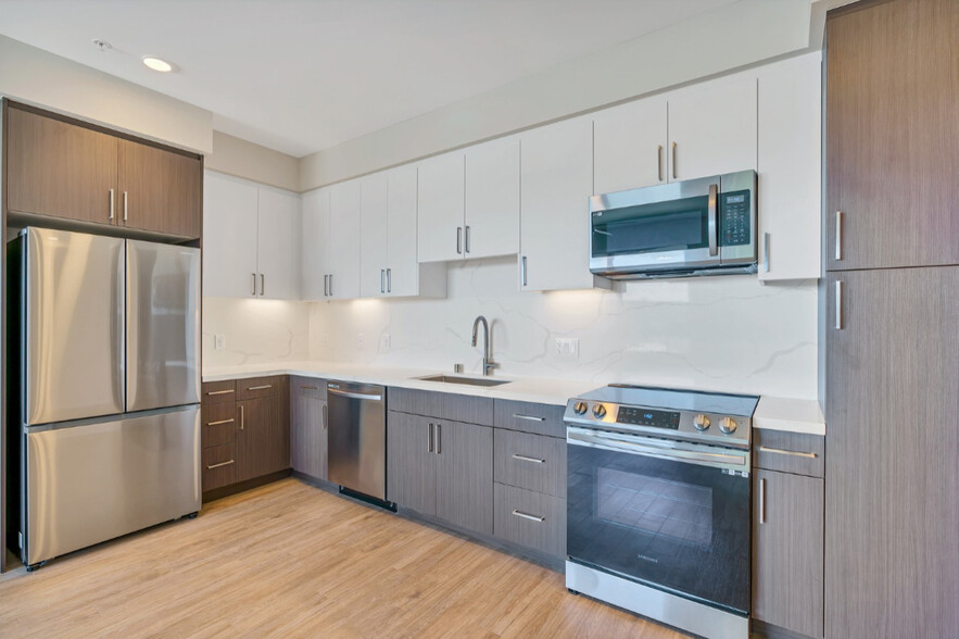 This full kitchen has a large sink, French-door fridge, dishwasher, microwave, stovetop oven, and a - Evoc Hillcrest