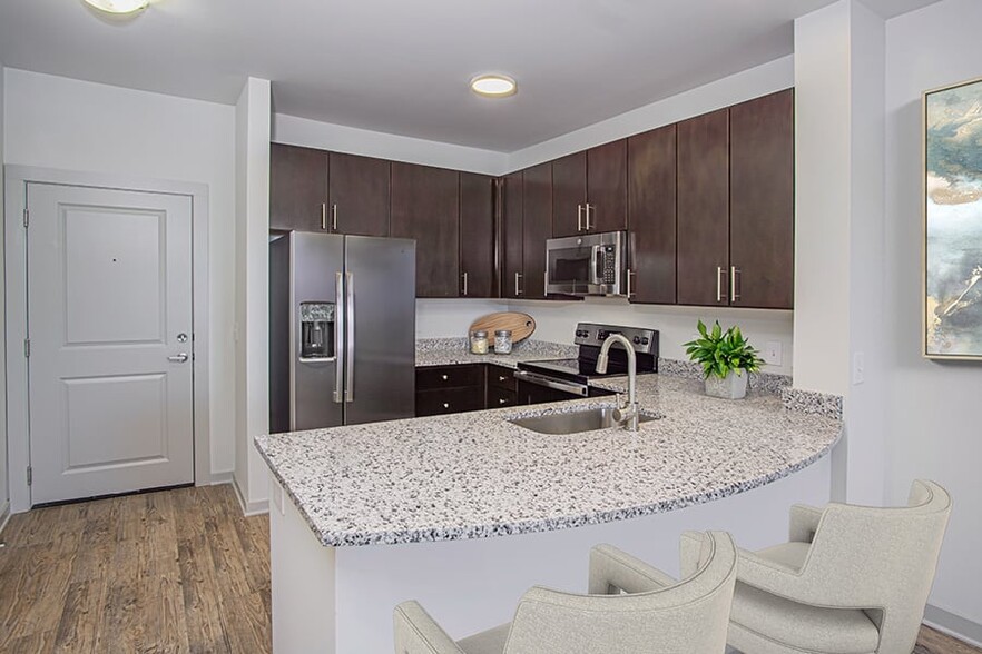 Beautifully renovated kitchens feature granite countertops and stainless steel appliances - Gramercy Square at Ayrsley