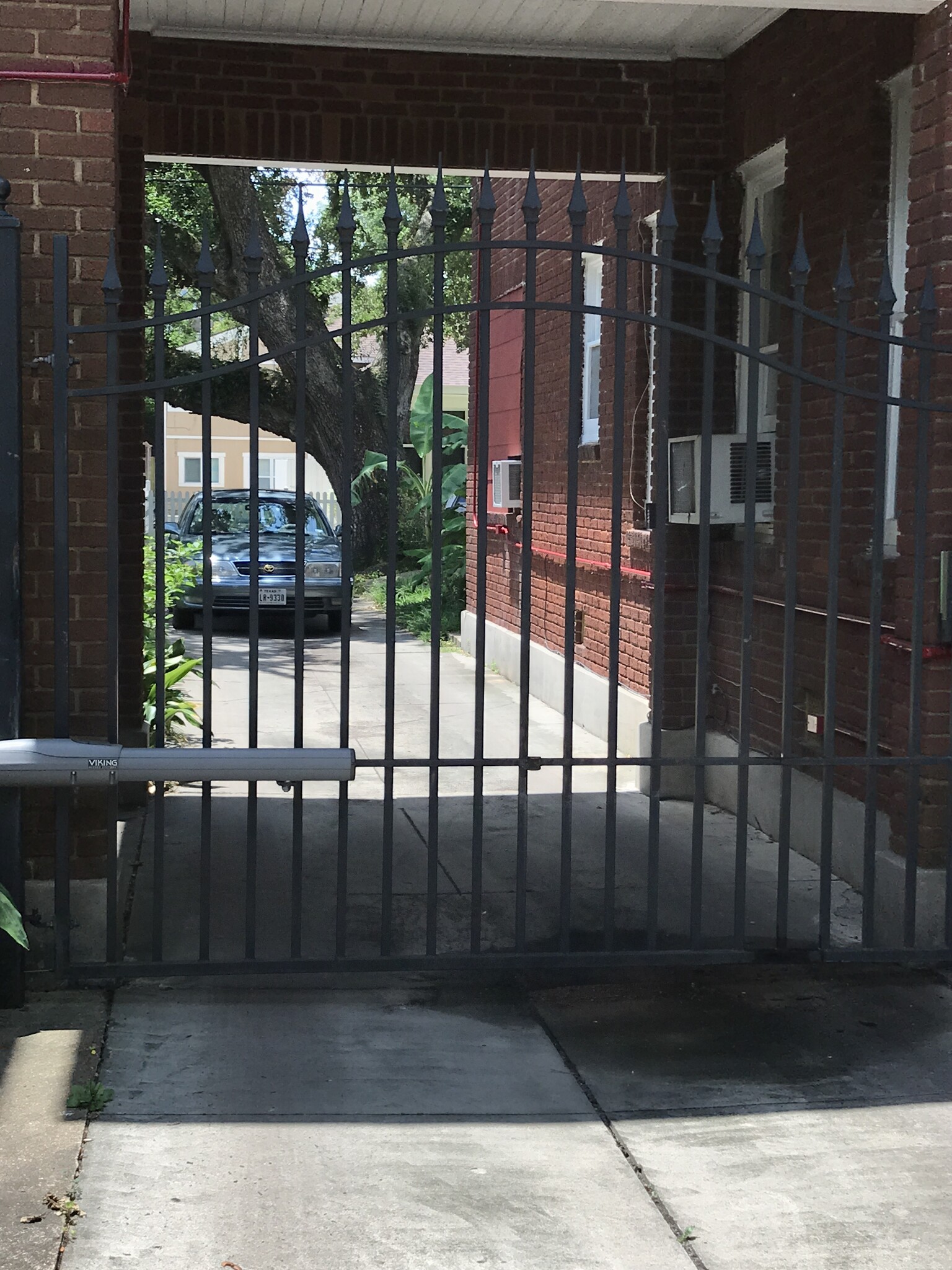 Behind a tall, spikey wrought iron fence - 812 Branard St