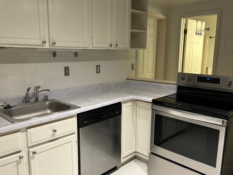 White kitchen features modern stainless appliances - 1901 E Lombard St