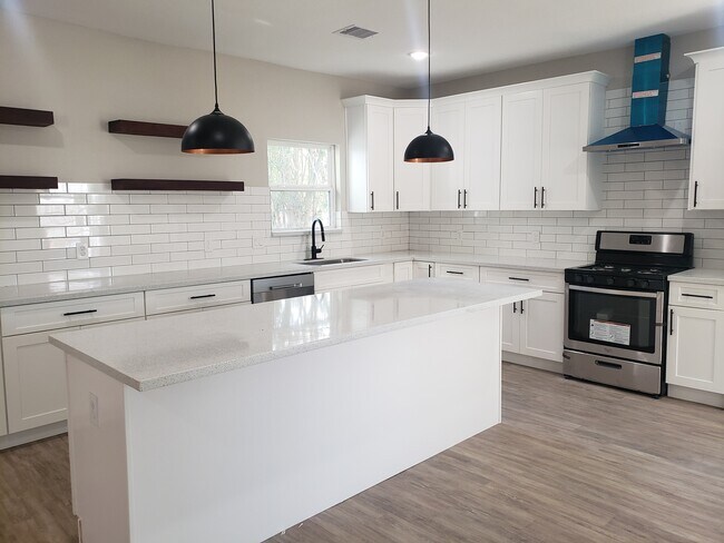 Large quartz island and new stainless steel appliances with gas stove - 936 W Austin St