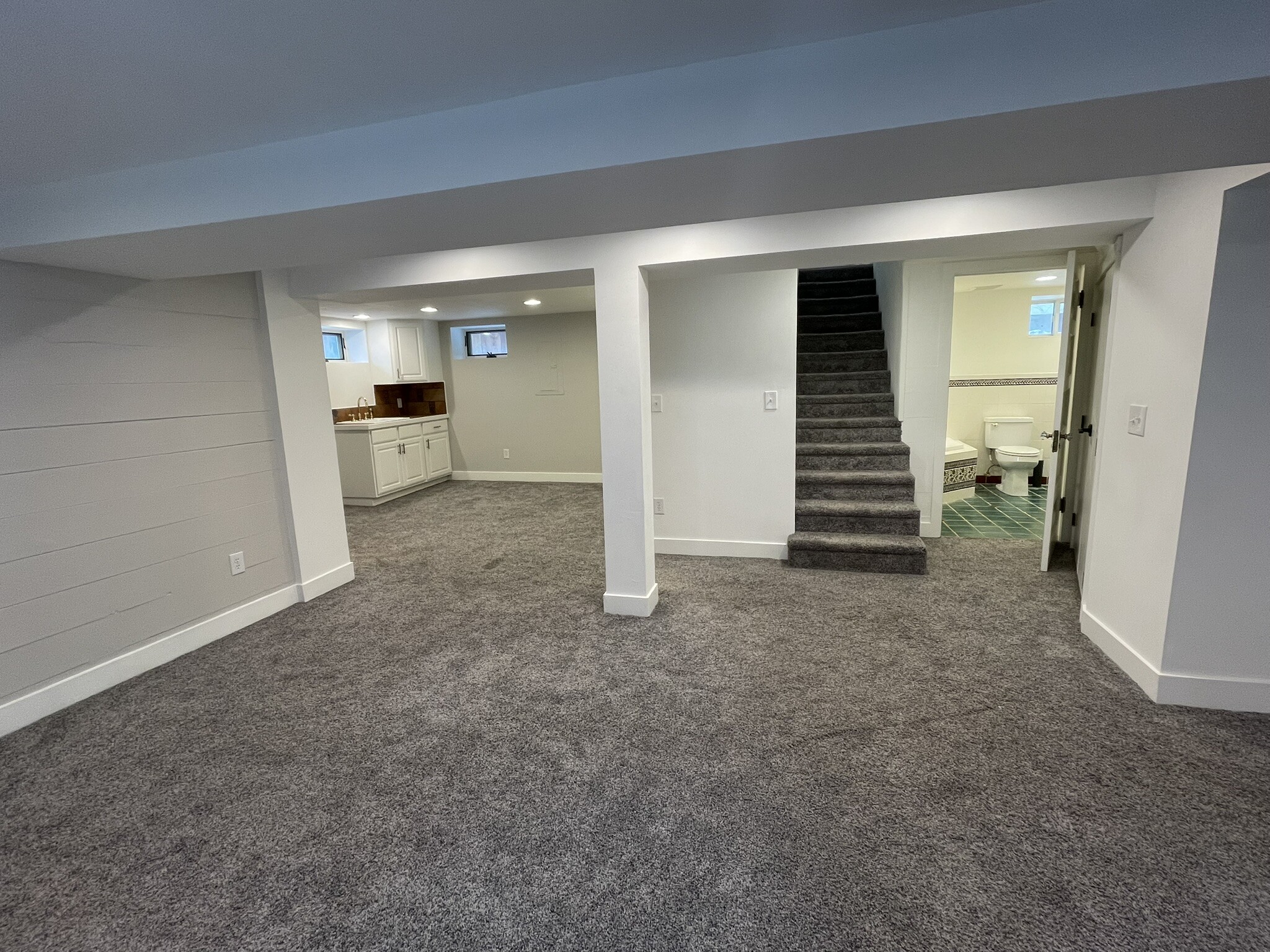 another view of open plan for basement showing stairs to main floor and ensuite bathroom - 508 Daly Ave