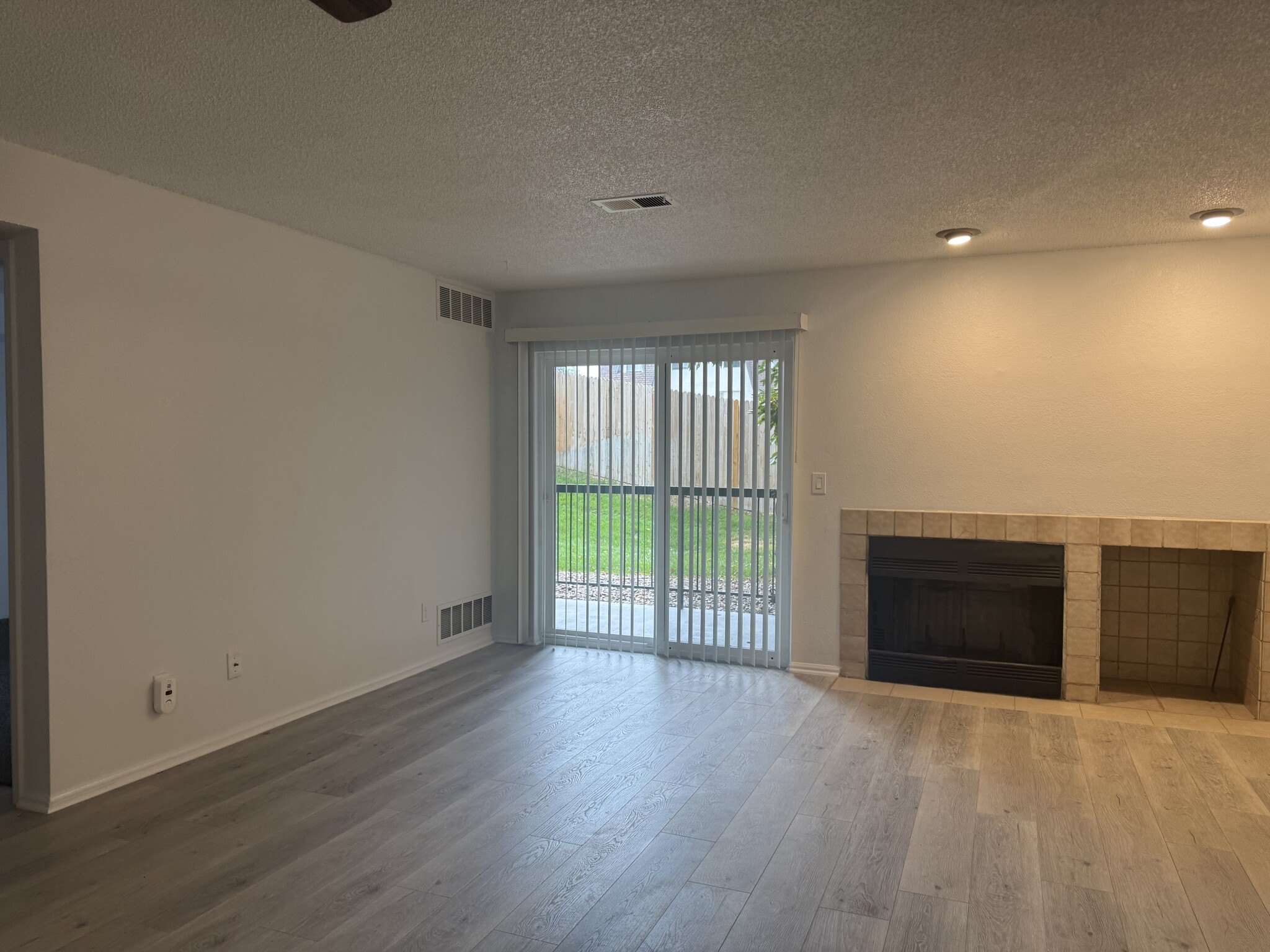 Living room with wood burning fireplace and area for wood storage to the right - 2575 S Syracuse Way