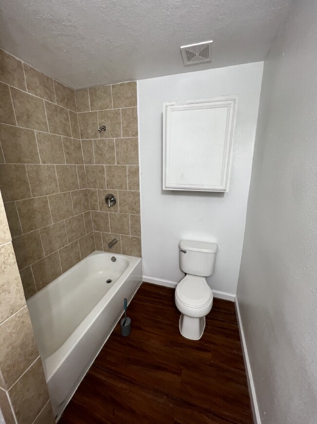 View of tub with new tile and bathroom floor - 116 Frawley St