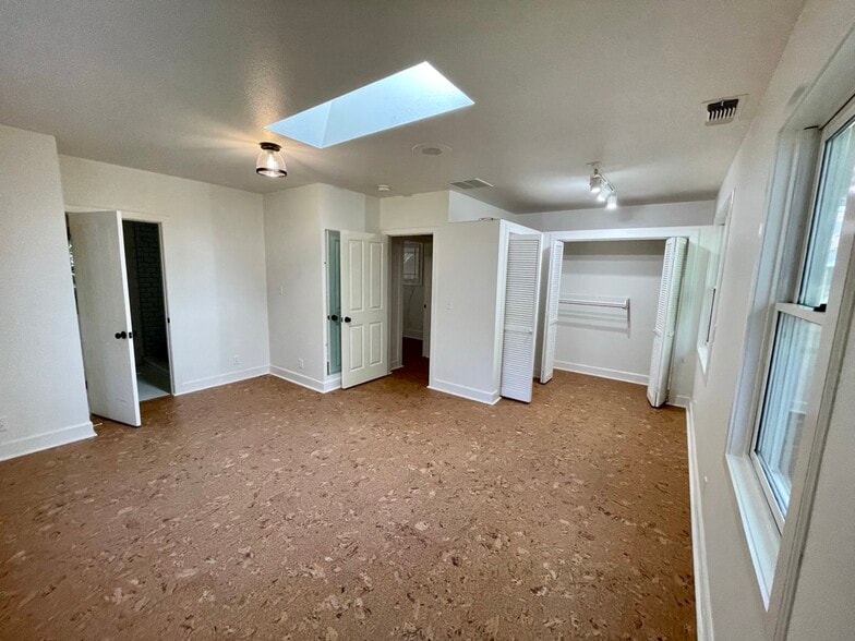 Large primary suite with partner closets and skylight. - 6605 Shady Lake Ln