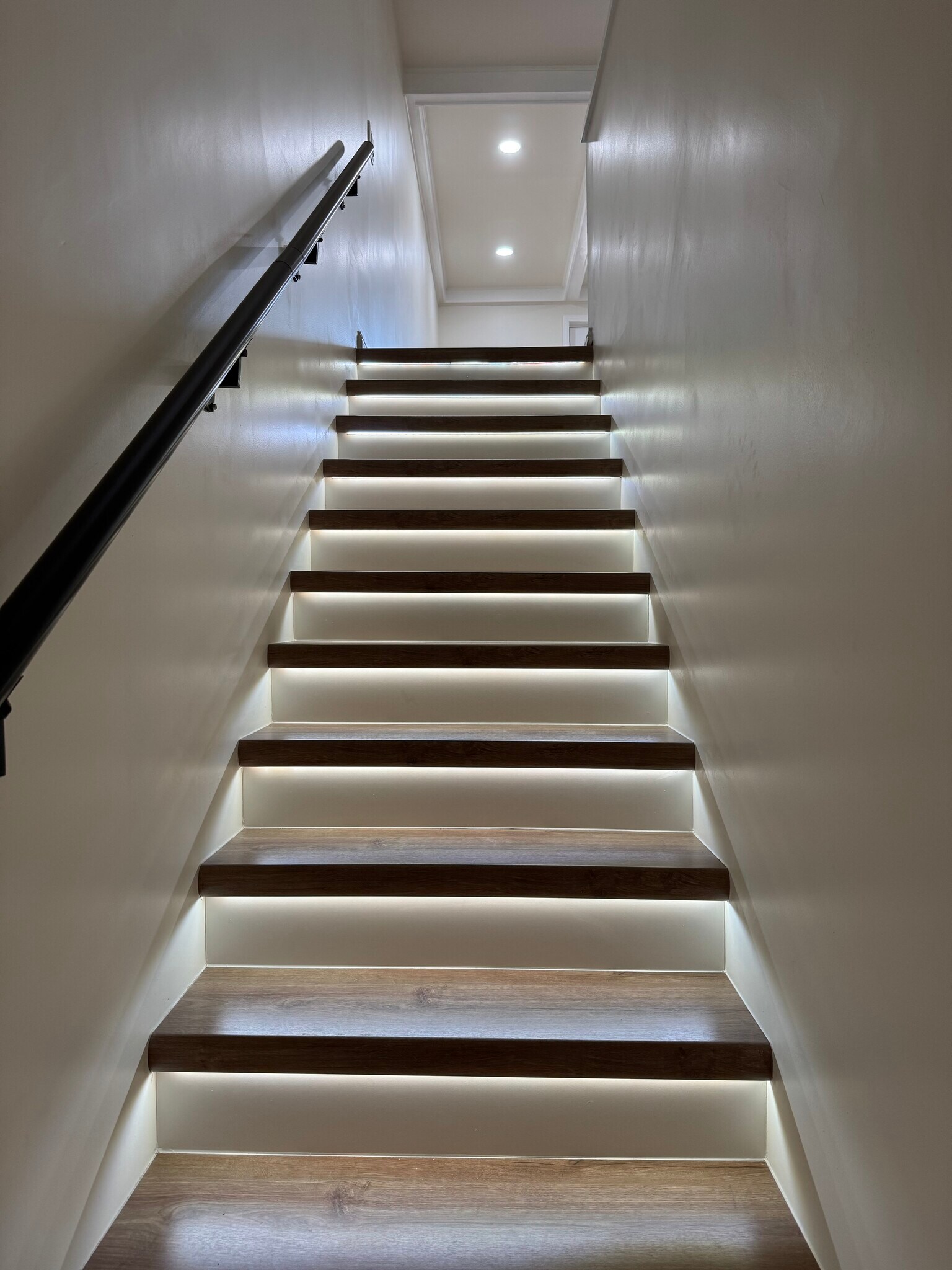 Modern wood staircase with motion-sensor LED lighting—sleek, safe, and energy-efficient design. - 328 N Allen St