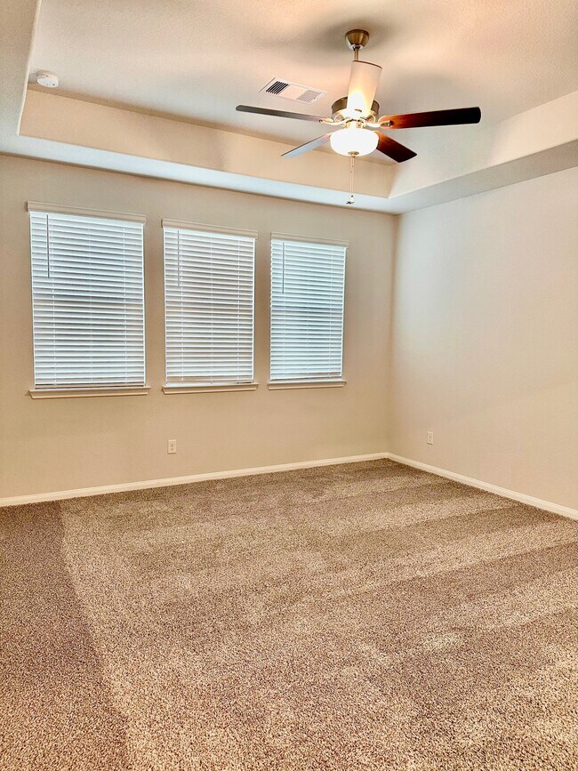 The large primary bedroom features a ceiling fan, carpet and blinds! - 507 Turtle Dove Dr
