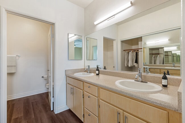 Renovated Package I bath with laminate countertops, oak cabinetry, and updated hard surface flooring - Avalon Mission Oaks