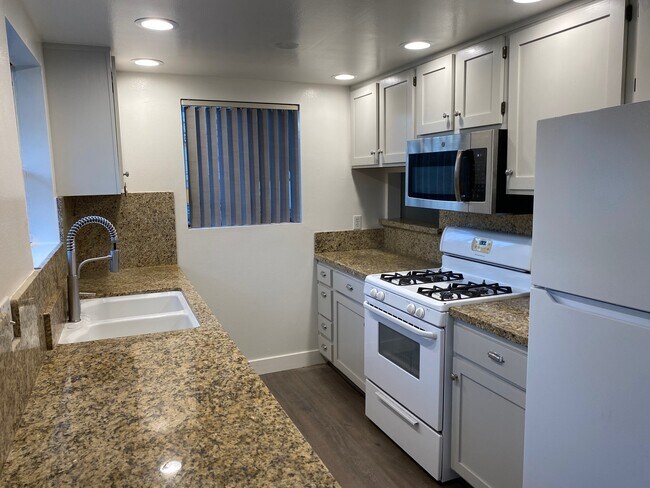 Kitchen with granite counter tops, stove, microwave & refrigerator - 10330 Riverside Dr