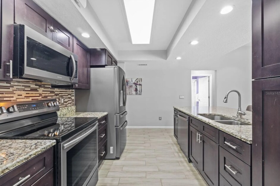 Fully stocked modern kitchen with granite countertops and stainless steel appliances. - 1932 Brainerd Ct