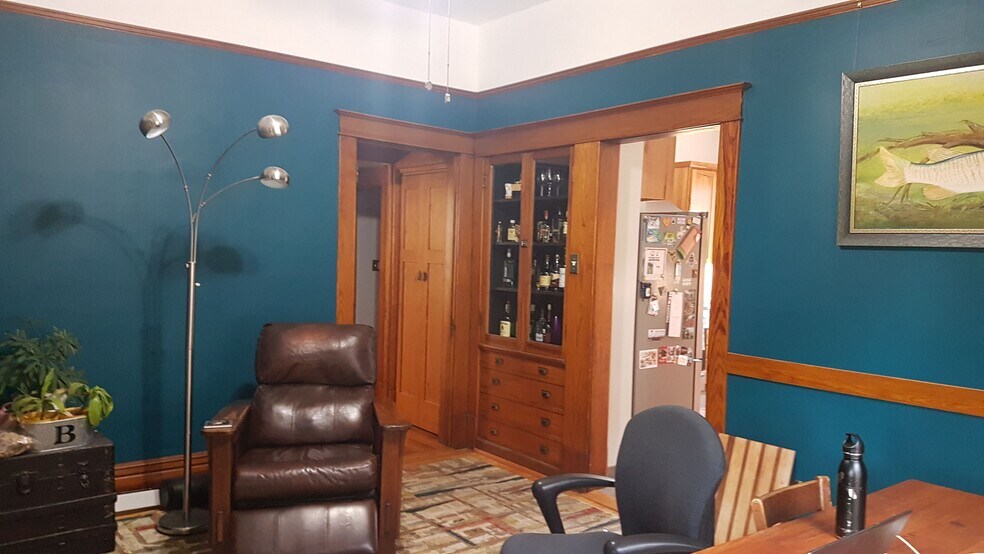 Dining Room with built in cabinet, closet at the bottom of the stairs, and a side view of the fridge - 407 S. 6th Street
