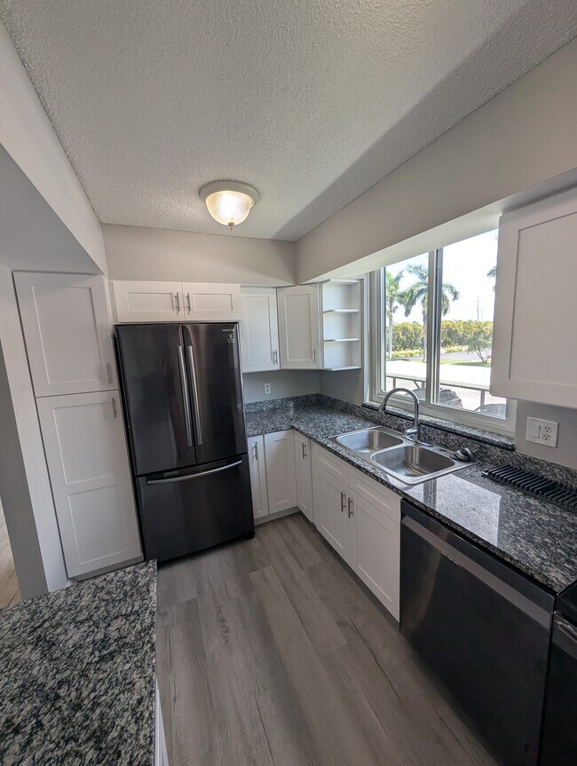 Kitchen with brand new cabinets and floors! - 3462 NE Causeway Blvd