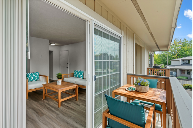 Relax on the charming balcony, perfect for enjoying peaceful views. - University Crossing Apartments