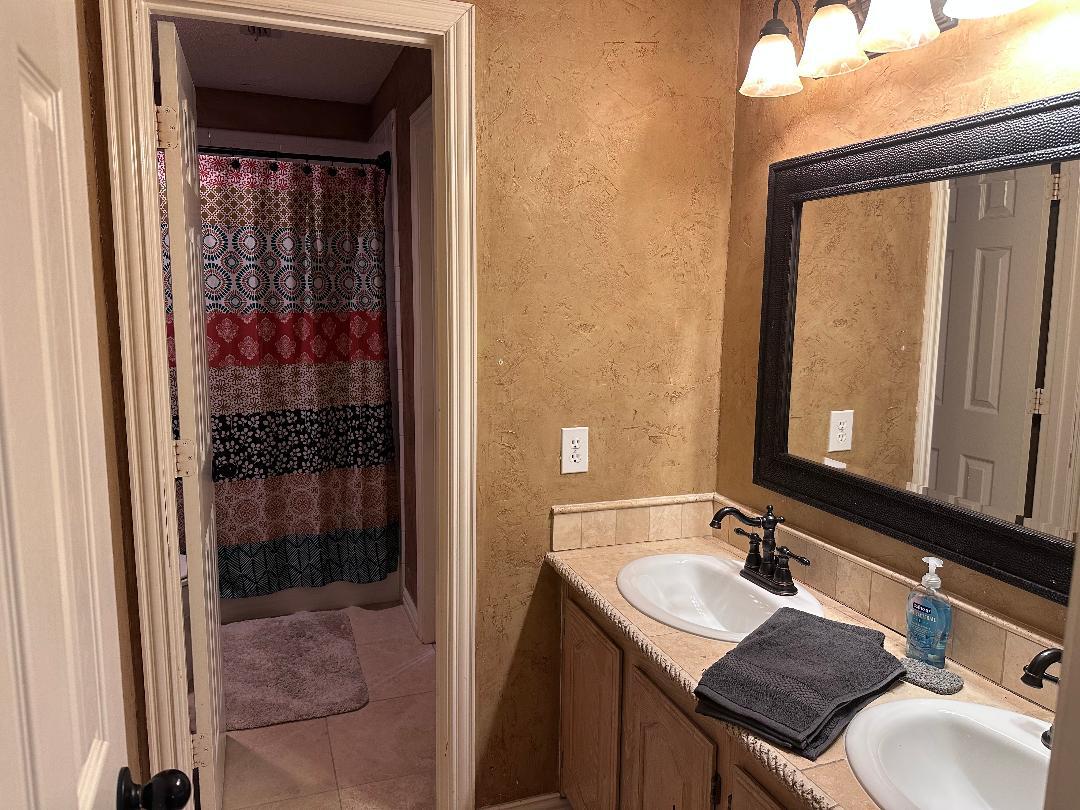 This refined en suite bath, connected to the second-floor queen suite - 10913 Alexandria Dr