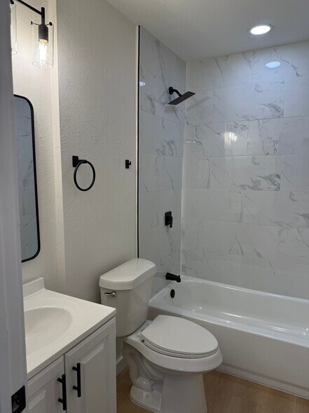 Main bathroom with rainfall shower head and tub. - 308 E Bourn St