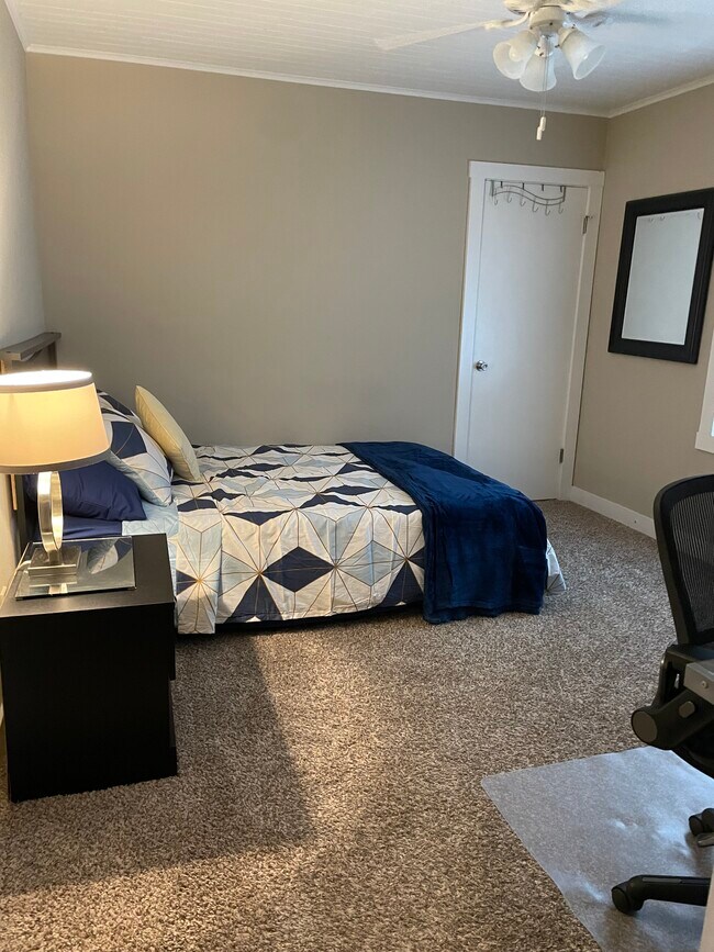 Main floor bedroom, queen bed, desk, dresser, and stroage drawers under bed. - 110 NE 40th St