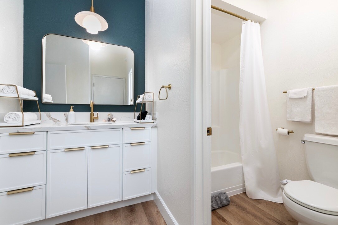 Bright full hotel-style bathroom with shower/tub combo and gold accents - 2221 Ocean Ave