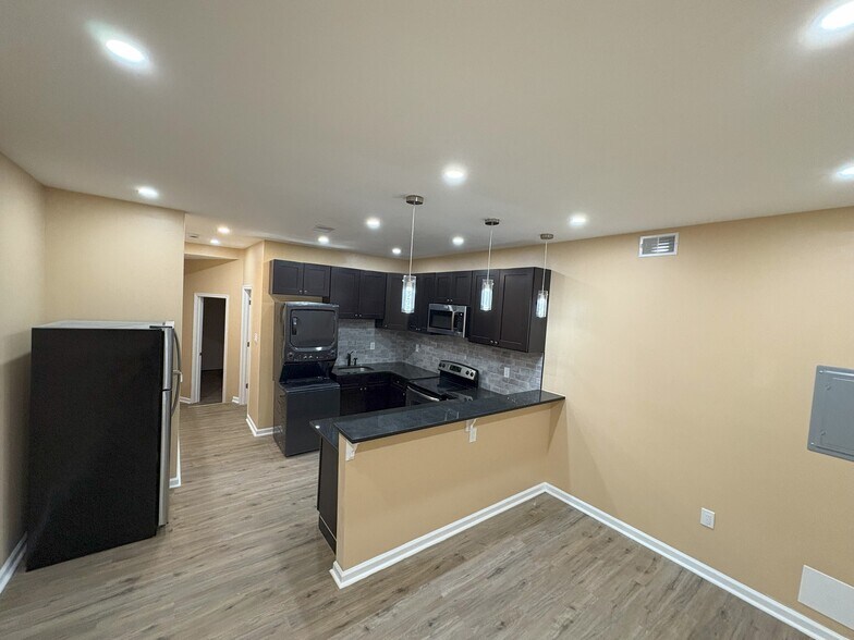 open kitchen concept with recessed lighting and focus lighting over the bar - 2214 N Delhi St