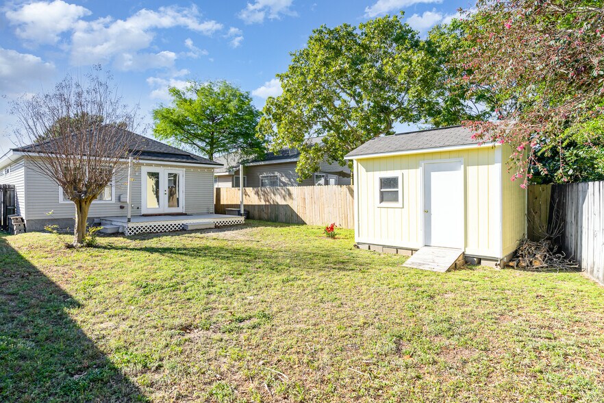 A spacious yard with a deck along with a privacy fence. - 6464 Starfish Cv