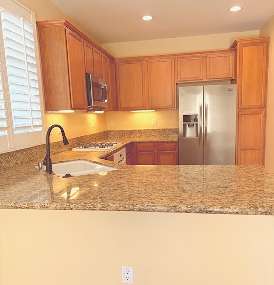 Open concept kitchen that includes granite countertop, plenty of storage and all appliances - 26019 Brinton Plz