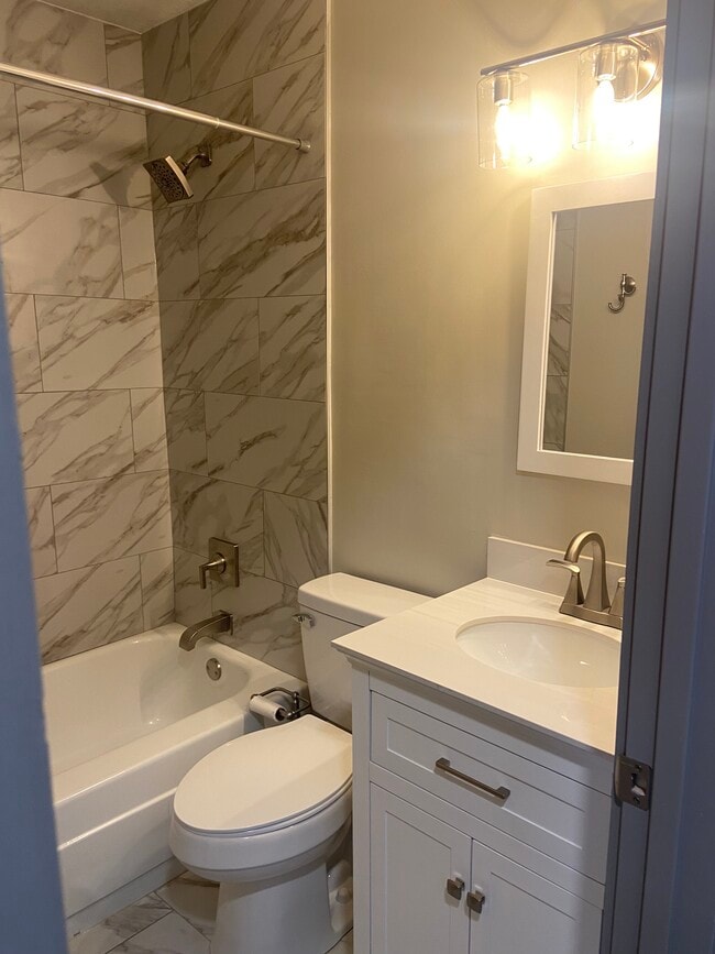 Hall bathroom with new tile, vanity, toilet, and linen closet - 174 Brisbane Ave