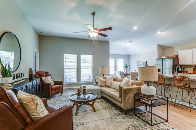 a living room with furniture and a ceiling fan - Cottages at Parkstone