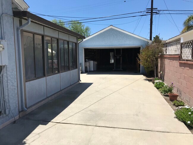 Driveway behind gate provides parking for extra cars or RV. Two-car garage has storage, workbench, - 14911 Fonthill Ave