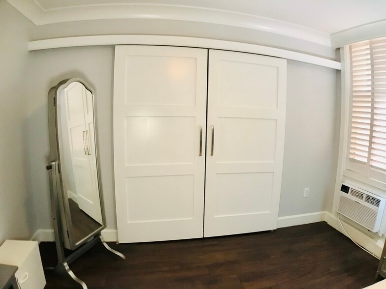 Bedroom features a standing mirror (with jewelry box storage) and farm-style closet doors. - 15 S Golfview Rd