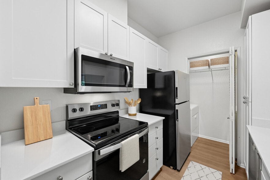 Renovated Package I kitchen with updated stainless steel appliances, white cabinetry, white quartz countertops, and hard surface flooring - eaves Dublin