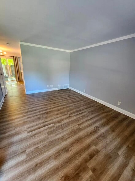 Private fenced patio with fresh landscaping, garden beds, and shaded greenery—perfect for relaxing o - 21 Richmond Sq