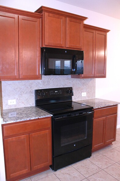 The kitchen is set with microwave, electric stove/over, dishwasher, and Refridgerator. - 1027 Aurora Grove Bnd