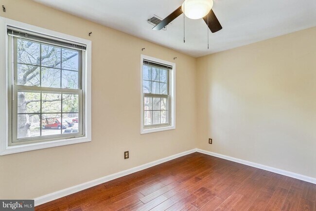 Well-lit bedroom with ceiling fan. - 1415 E Abingdon Dr