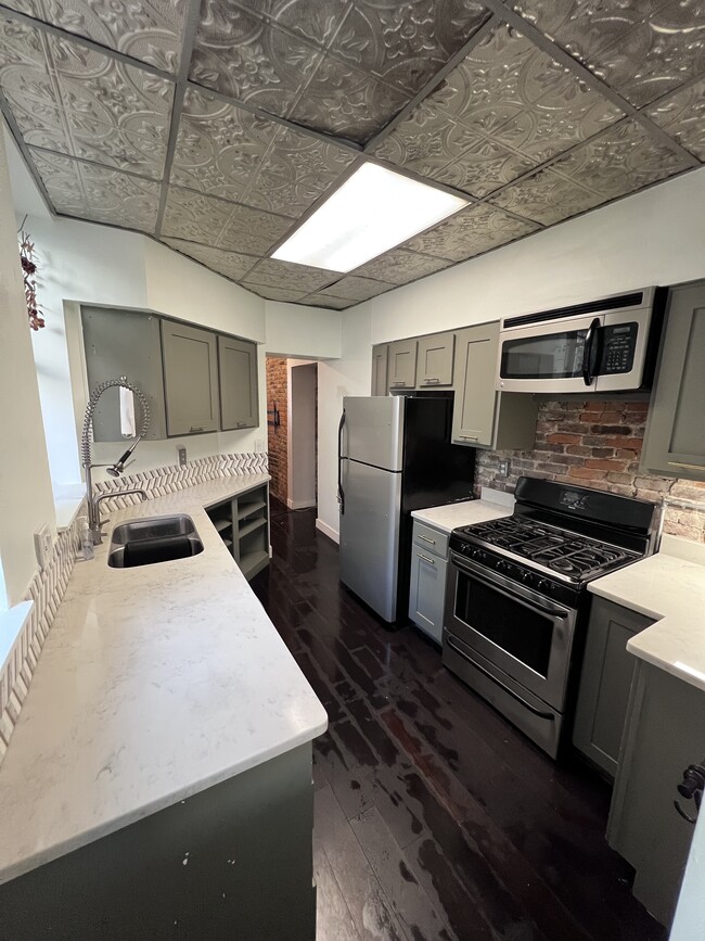 First floor: Kitchen (gas stove, microwave, granite countertops, double-bowl sink, garbage disposal) - 103 S 22nd St