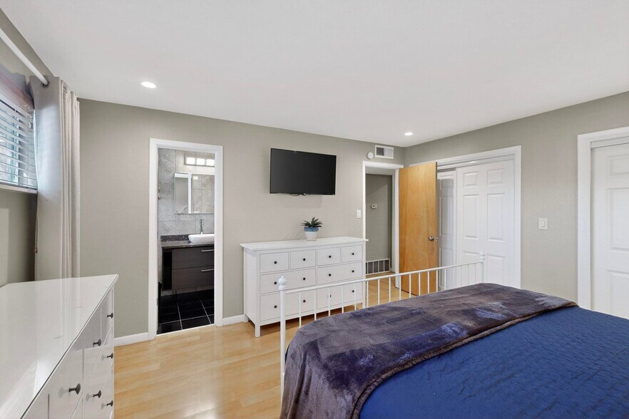 primary bedroom with king bed, attached bathroom, double closet, smartTV - 4715 Marquette Ave NE