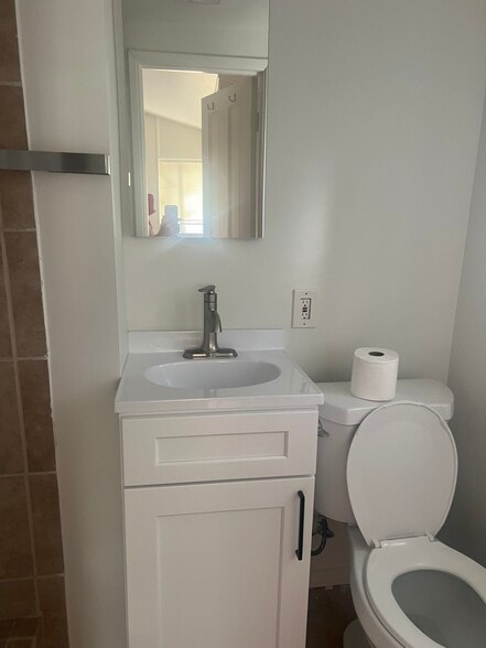 Bathroom sink, mirrored medicine cabinet, toilet - 15138 Encanto Dr