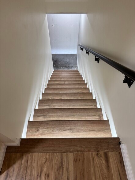 Modern wood staircase with motion-sensor LED lighting—sleek, safe, and energy-efficient design. - 328 N Allen St