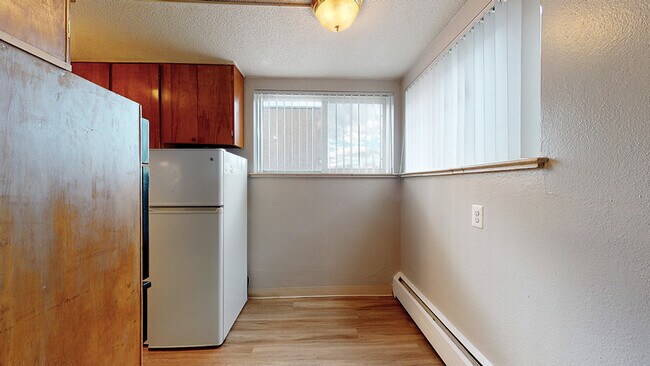 Experience a cozy kitchen that welcomes natural light, perfect for culinary inspiration. - Harmony Apartments