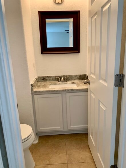 Half bathroom on main floor with new toilet, granite, sink & fixtures - 10219 Roseangel Ln