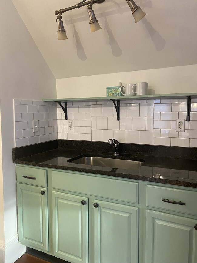 Kitchen with open shelving and tile backsplash, granite counter. - 16 Eames St