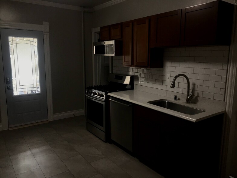 Kitchen, door leading to screen porch and brick patio. - 1233 Jenifer St