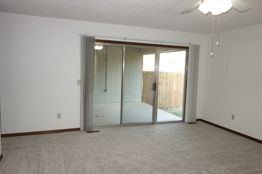 Master bedroom with view of sliding patio doors leading to covered back patio and yard - 3324 E 73rd St