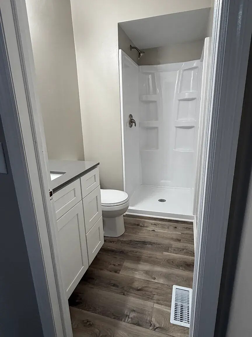 En suite bathroom with new vanity, sink, quartz countertop, faucets, toilet, and shower - 6718 S 87th St